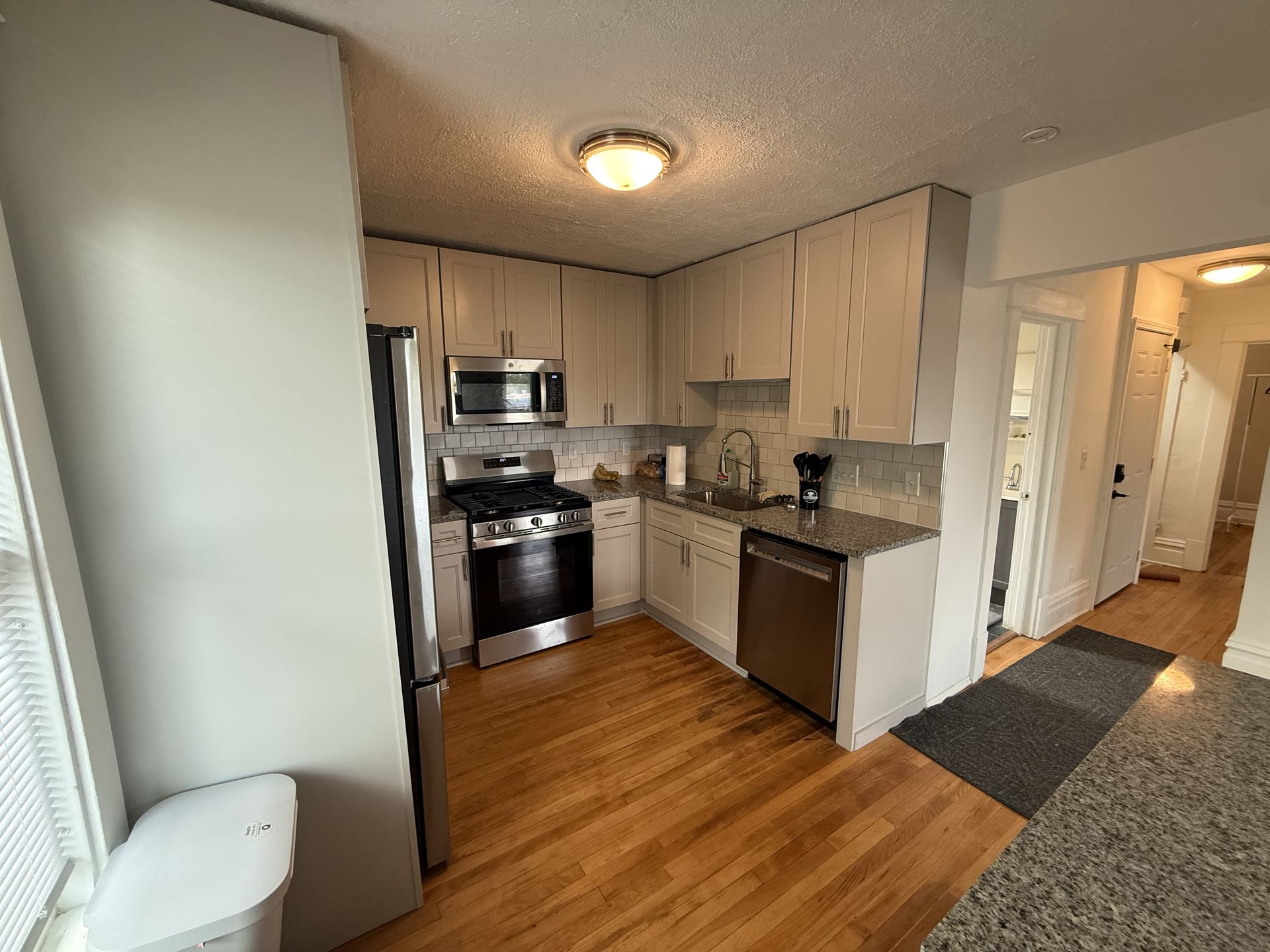 Kitchen with white cabinetry, hallway view